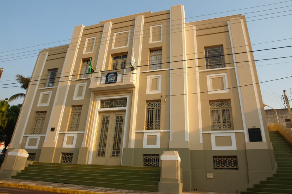 Fachada do Paço Municipal de Pederneiras, com o brasão do município sobre a porta principal.